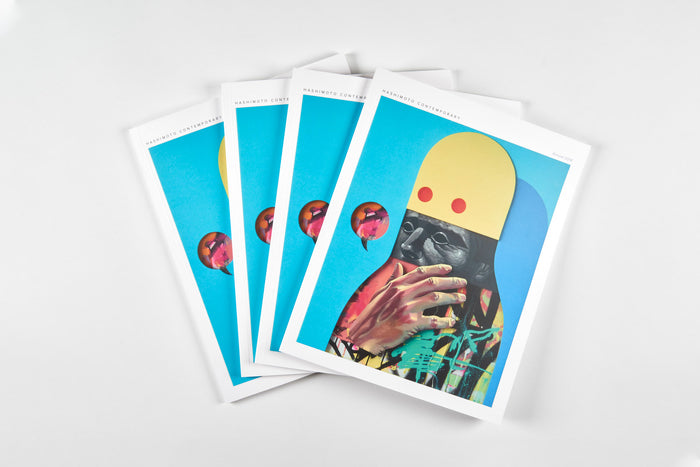 Four fanned magazines on a white surface display the vivid cover of the 2018 Hashimoto Contemporary Annual by Paragon Books. Featuring a colorful abstract portrait with two red dots and a speech bubble containing a bird, it captures the dynamic spirit of Hashimoto Contemporary Gallerys 2018 solo exhibitions.