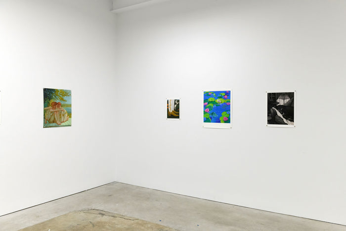 A minimalist art gallery corner features four stunning wall-mounted artworks: Angela Fang Zirbes Dog on Couch print, a limited edition couple under a tree, an abstract piece, and an archival pigment print of a piano player. It all contrasts against the bare concrete floor.