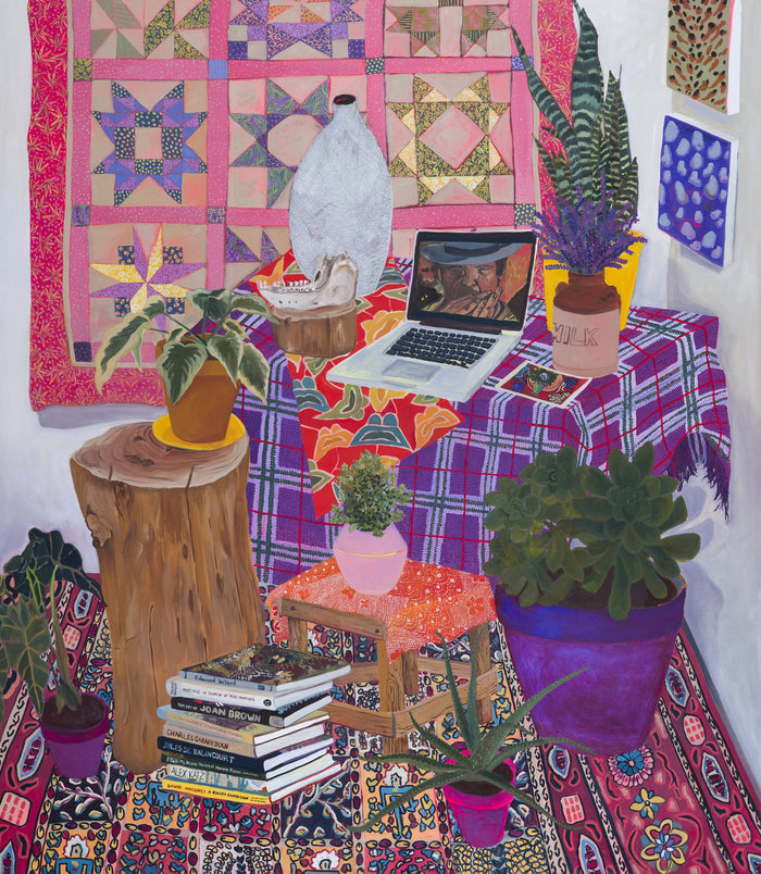 The vibrant indoor scene showcases plants, a laptop, and books. A colorful quilt is displayed on the wall above Anna Valdezs archival pigment print titled References. A wooden stool supports a potted plant, with patterned fabrics covering the floor and table. This limited edition piece is signed and numbered for collectors.