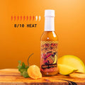 Bad Boy Mango Madness hot sauce bottle with white cap, 8/10 heat level, displayed with mango and cilantro