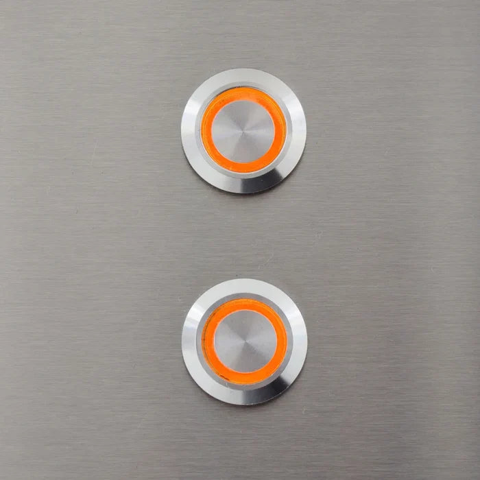 Two round stainless steel LED lights with white bezels and orange amber centers on brushed metal surface