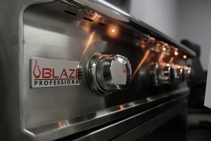 Blaze Professional stainless steel grill control panel with illuminated knob and amber burner lights lit