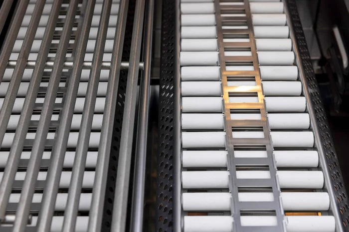 Stainless steel grill burners with ceramic rods and metal framework in outdoor kitchen configuration