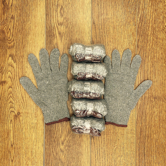 Gray heat-resistant grill gloves with five sausages on wooden surface