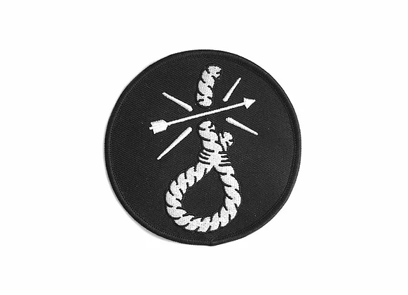 The limited edition Cheat the Gallows patch by Christopher Martin is round and black with an iron-on design featuring a white noose and an arrow crossing it, enhanced by three bold diagonal white lines.