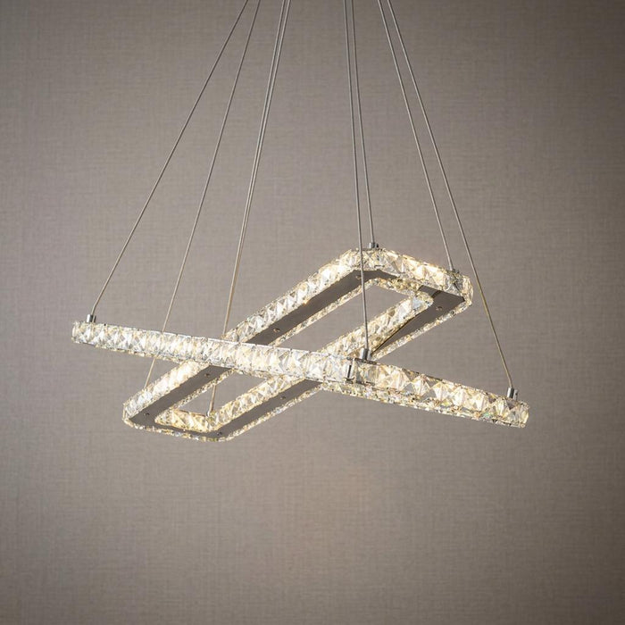 Intersecting chrome and crystal rectangular LED ceiling pendant hanging against a textured neutral wall.