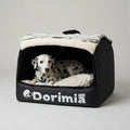 Dalmatian resting inside an enclosed black dog bed with plush cushion