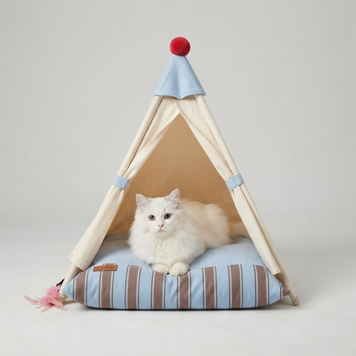 White cat resting inside a beige pet tent bed with blue striped cushion