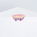 Mini #15 by Dan Lam is a small, colorful art piece with prickly textures in vibrant pinks and purples on a stark white angular surface. Crafted from acrylic and hot glue, it creates a striking contrast.