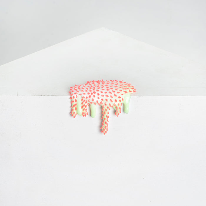 Dan Lams Mini #26 showcases a textured white wall with a dripping pattern reminiscent of melting pink and green slime, accented by small raised pink dots, all set against a light gray background resembling the smooth finish of resin.