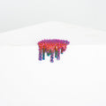 Dan Lams Mini #28 features a colorful, spiky, abstract resin design with vivid pink, blue, and red hues. The piece appears to drip off a white surface against a light background.
