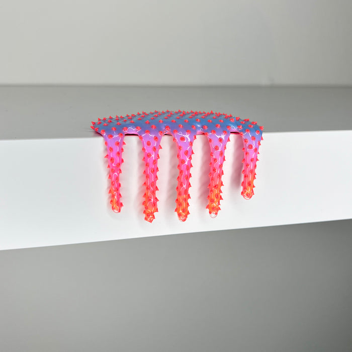 The 2023 mixed media artwork Mini #367 by Dan Lam features a vibrant, spiky, slime-like form that drips over a white surface. The piece transitions from pink to orange with a textured, three-dimensional appearance.