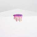 The Mini #37 by Dan Lam is a small, colorful resin sculpture resembling a melting scoop of spiky ice cream with vibrant pink and green spikes, perched on a white angular pedestal against a plain gray backdrop.