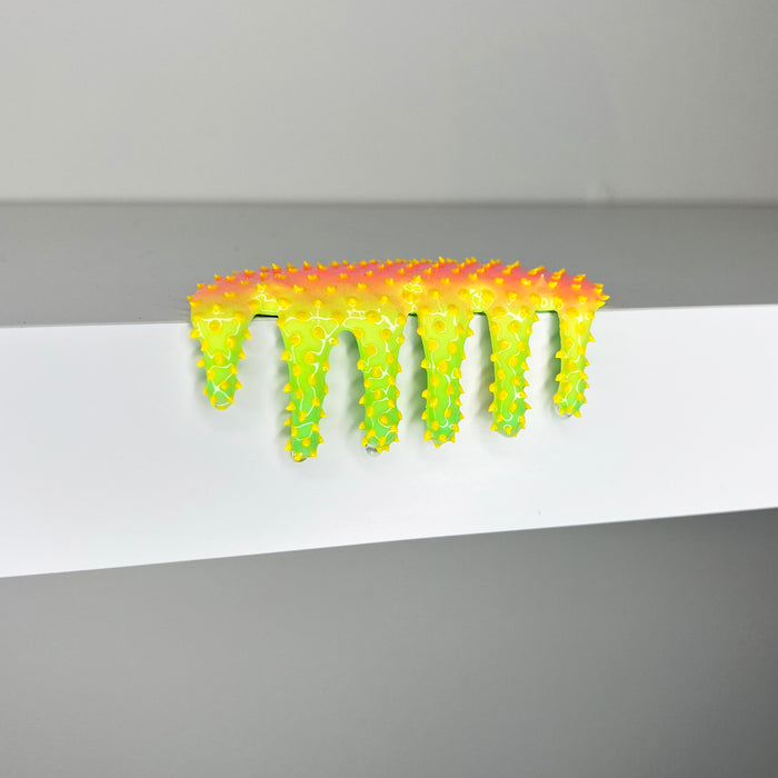 Dan Lams Mini #459 exemplifies 2023s mixed media trend with its bright yellow-green spikes and dripping effect on a smooth gray surface, creating a striking gradient from yellow to green.