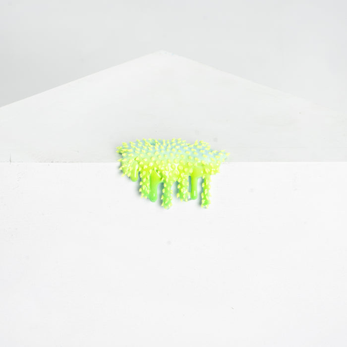 Dan Lam - 'Mini #50' by Dan Lam: a white envelope topped with a vibrant, neon yellow-green resin sculpture featuring fuzzy, textured spikes, set against a plain white background.