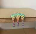 Dan Lam's "Mini #539" is a colorful mixed media piece from 2023, featuring spiky blue protrusions and a yellow-to-pink gradient that drips over the edge of a wooden shelf.