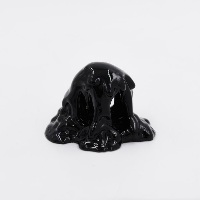 Dan Lams Mini #7.91 features a mound of glossy black liquid resembling acrylic paint, set against a plain white background. The thick liquid flows smoothly, creating a shiny surface.