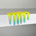 Dan Lams Mini #859 features a vibrant, neon spiky slime in a mixed media style, dripping over a white surface. Its glossy gradient transitions from yellow to green, with pink spikes scattered throughout, capturing the playful creativity of 2023.