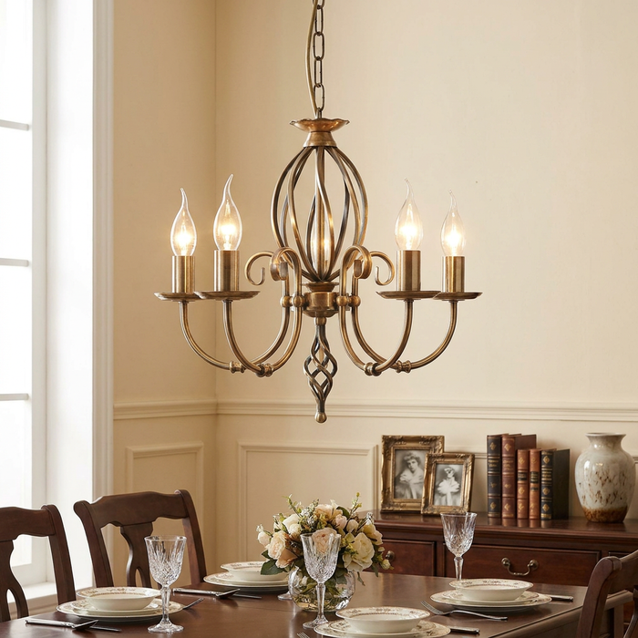 Aged brass 5-light chandelier hanging over a formal dining table in a traditional room.