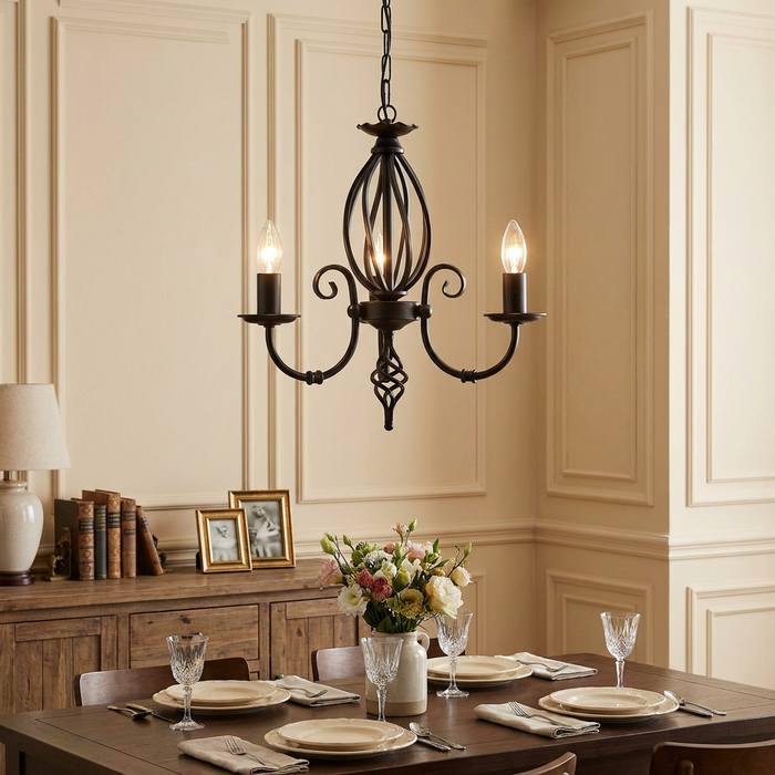 Wrought iron 3-light chandelier with a decorative cage center hanging above an elegantly set dining table.