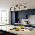 Focus 4 light bar ceiling spotlight in antique brass illuminating a modern kitchen with blue cabinets.
