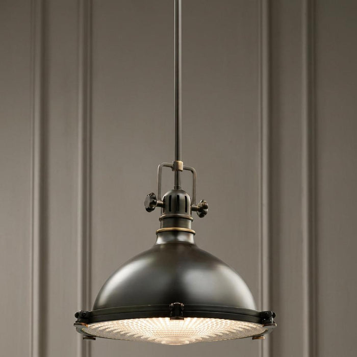 Kichler Hatteras Bay 33cm bronze pendant light with a domed shade and fresnel lens hanging in a room.