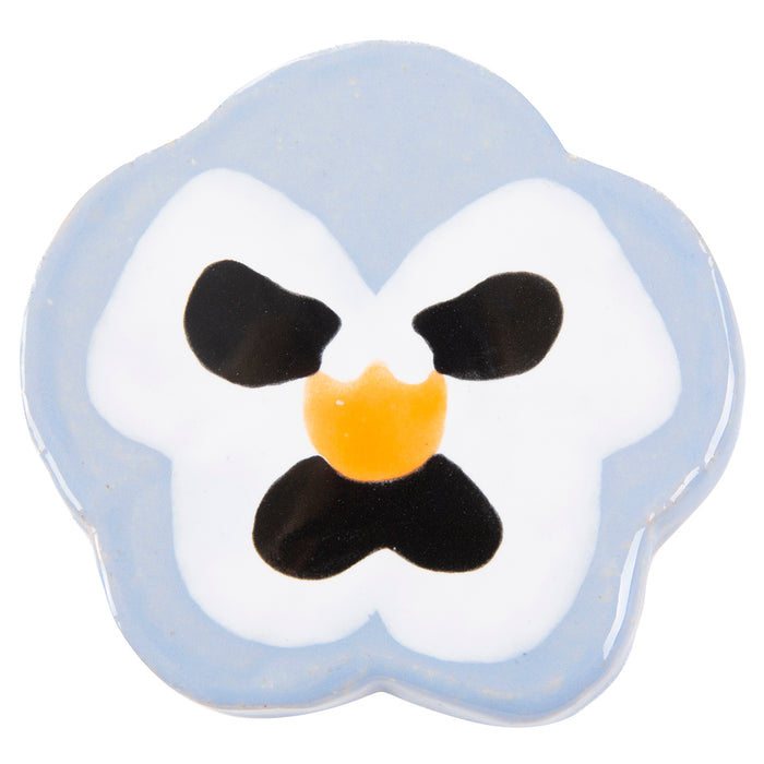 The Periwinkle Pansy ceramic plate by Lorien Stern at Hashimoto Contemporary resembles a pansy flower, with a pale blue outline, black petal details, and a vibrant yellow center, all in a simple and stylized design that captures natures delicate beauty.