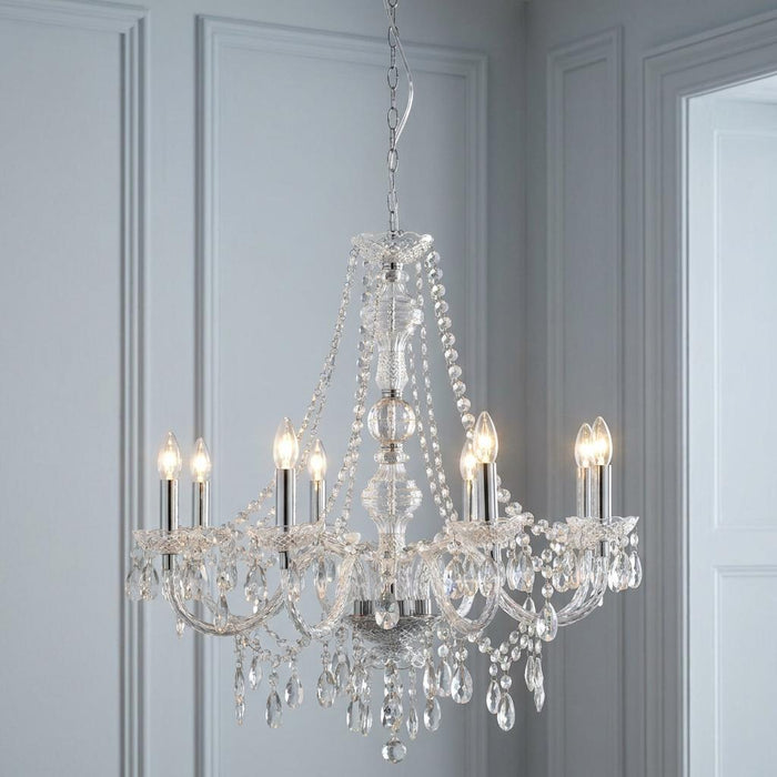 Eight-light Marie Therese chandelier with clear acrylic drops and candle bulbs against light blue paneled walls.