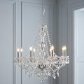Eight-light Marie Therese chandelier with clear acrylic drops and candle bulbs against light blue paneled walls.