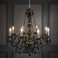 Searchlight Marie Therese 8 Light Grey Acrylic Chandelier with lit bulbs against a grey panelled wall.